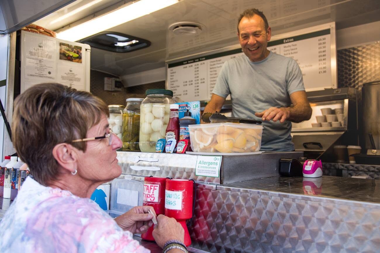 David chatting with a customer at the fish and chip van counter